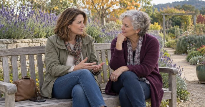 Two adult women talking privately on a garden bench.